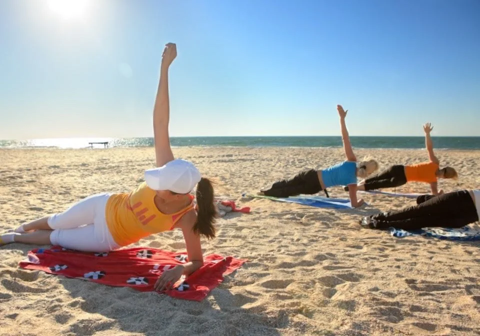 Athletes practising yoga on the beach