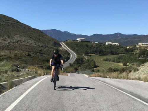 Female cyclist climbing a hill in Marbella